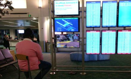 Passenger Takes Over Airport Monitor To Play Video Game